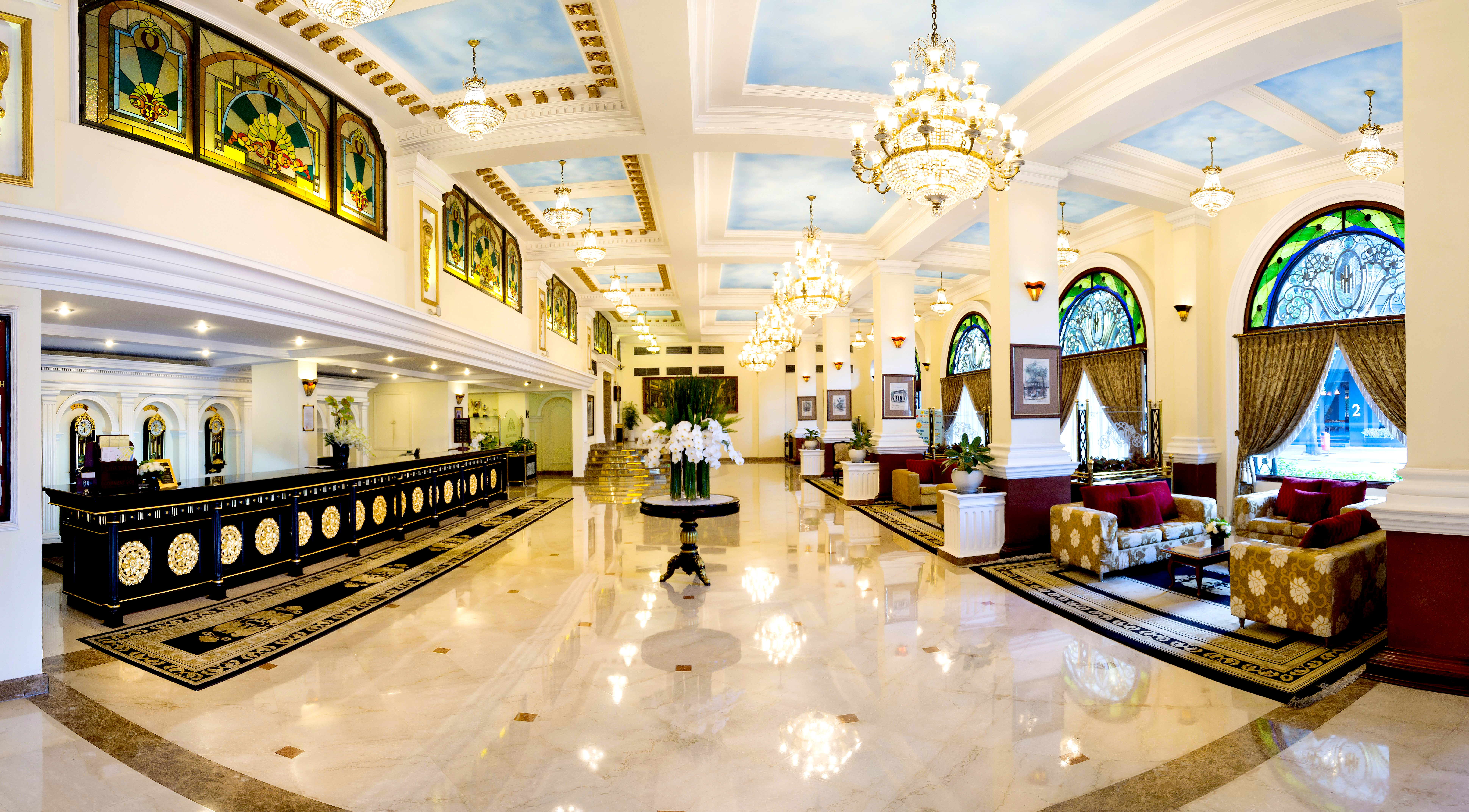 Majestic Hotel Saigon lobby, dark wooden desks, marble floors, chandelier, grand decor