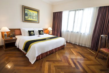 Majestic Hotel Saigon president suite, large double bed, wooden floor, bright modern decor