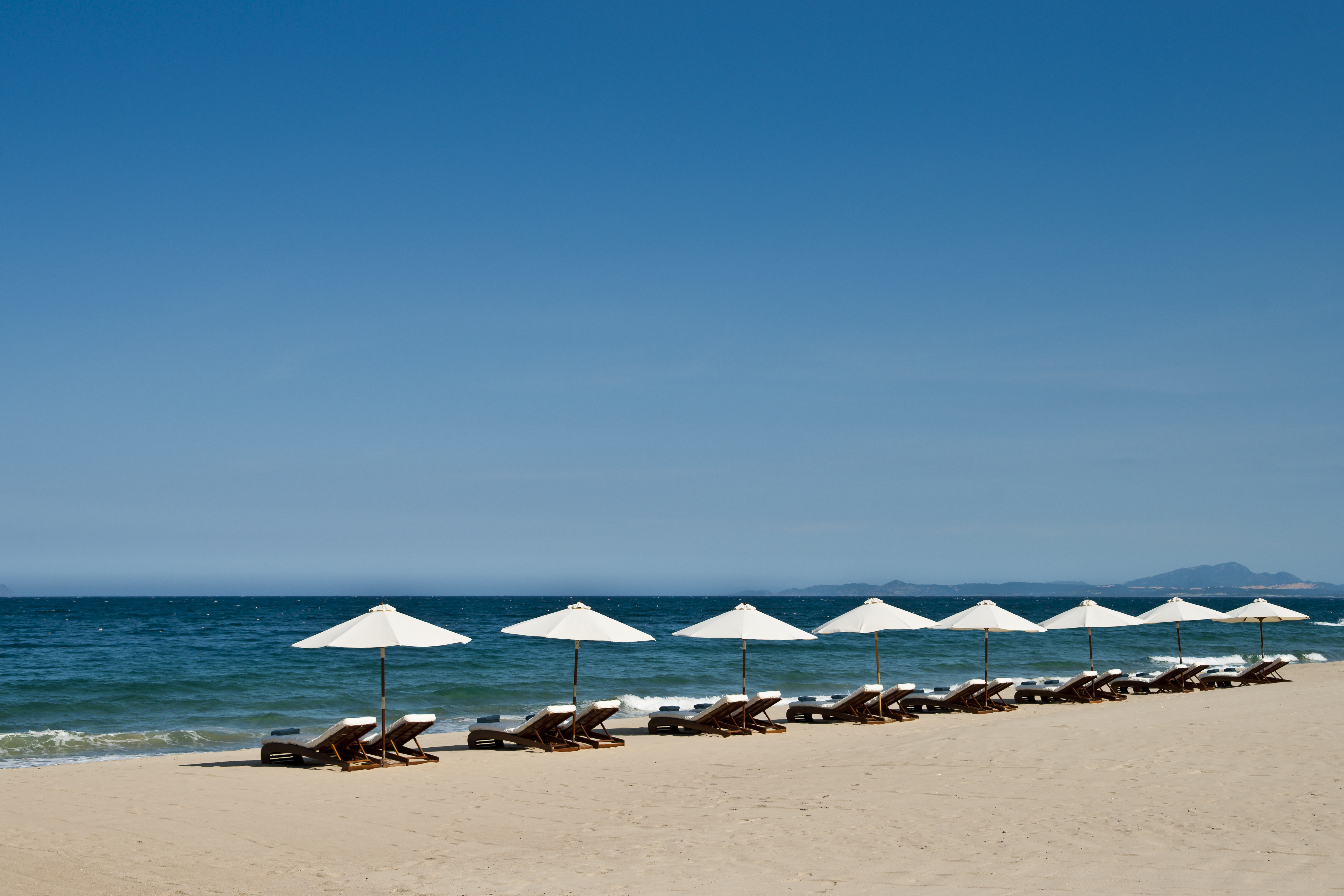 Mia Nha Trang Resort beach loungers, white sandy beach, clear blue sea, loungers and umbrellas