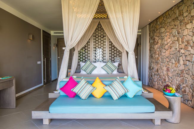 Mia Nha Trang Resort villa bedroom, double bed with canopy, sofa at end of bed, colourful modern decor