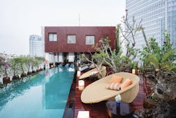 Pool view with large rectangular pool, seating pods set up around on wooden decking and plants