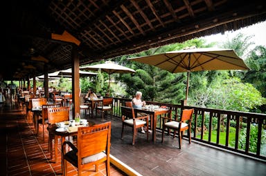 Palm Garden Resort terrace, outdoor dining area, tables, chairs, umbrellas, overlooking garden