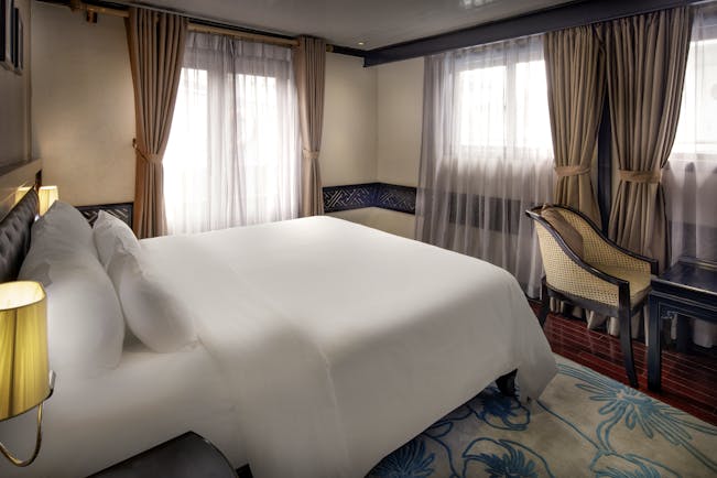 Paradise Luxury Cruise paradise suite, double bed, drapred windows, traditional decor