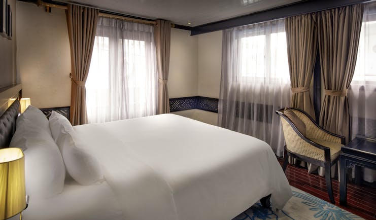 Paradise Luxury Cruise paradise suite, double bed, drapred windows, traditional decor