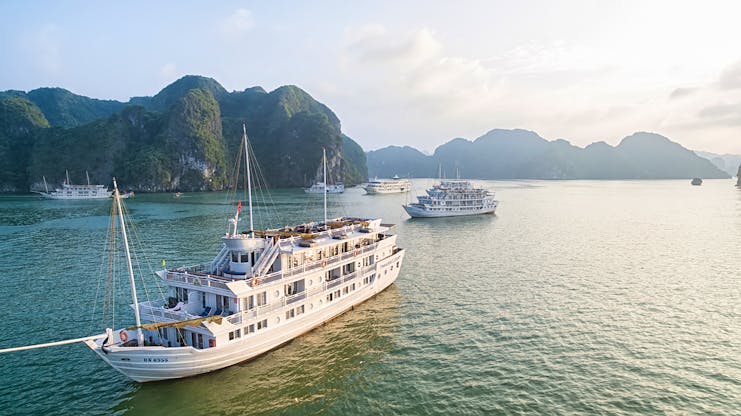 Paradise Luxury Cruise exterior of ship on water, rocks in background