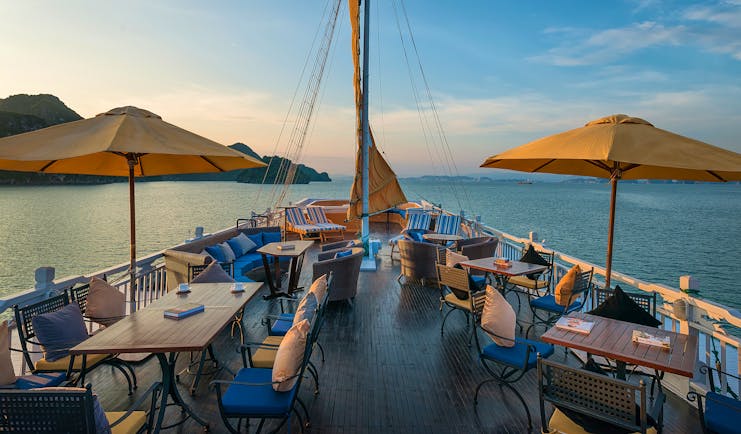 Paradise Luxury Cruise sun deck, tables and chairs on top deck of boat, views over the sea