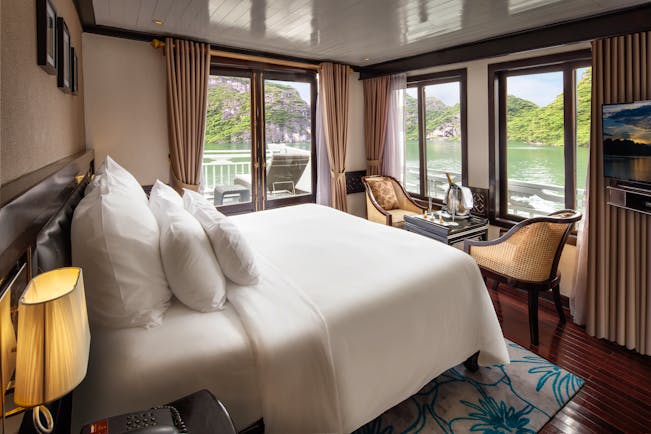 Paradise Luxury Cruise terrace suite, double bed, table and chairs, windows overlooking sea, traditional decor