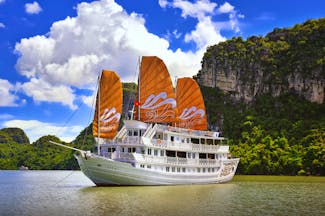 Paradise Peak Cruise boat, white boat, orange sails, boat on water, rock formation in background