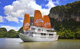 Paradise Peak Cruise boat, white boat, orange sails, boat on water, rock formation in background