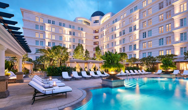 Park Hyatt Saigon pool, sun loungers, trees, hotel building in background