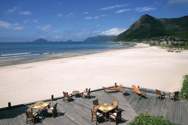 Six Senses Vietnam beach deck terraced seating area on beach front mountains in background