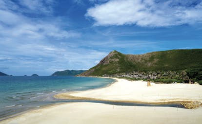Six Senses Vietnam beach white sandy beach ocean mountain in background