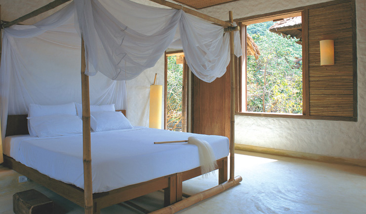 Six Senses Ninh Van Bay Vietnam bedroom white four poster bed with drapes garden view