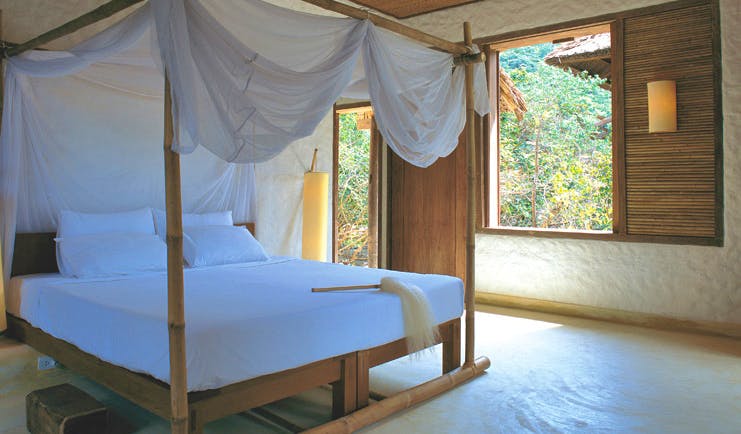Six Senses Ninh Van Bay Vietnam bedroom white four poster bed with drapes garden view