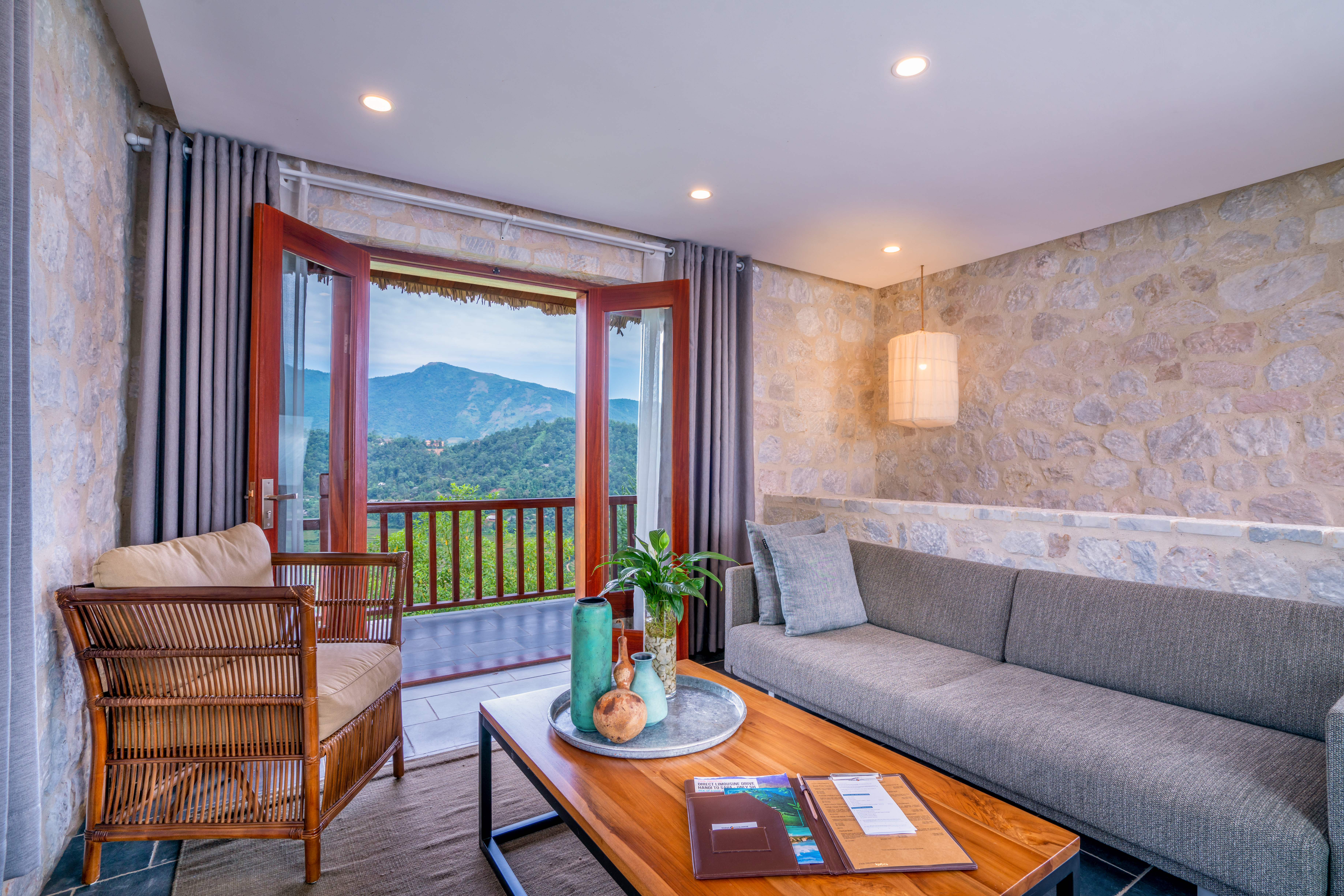 Topas Ecolodge suite bungalow lounge, sofa, modern decor, doors opening to balcony with mountain views