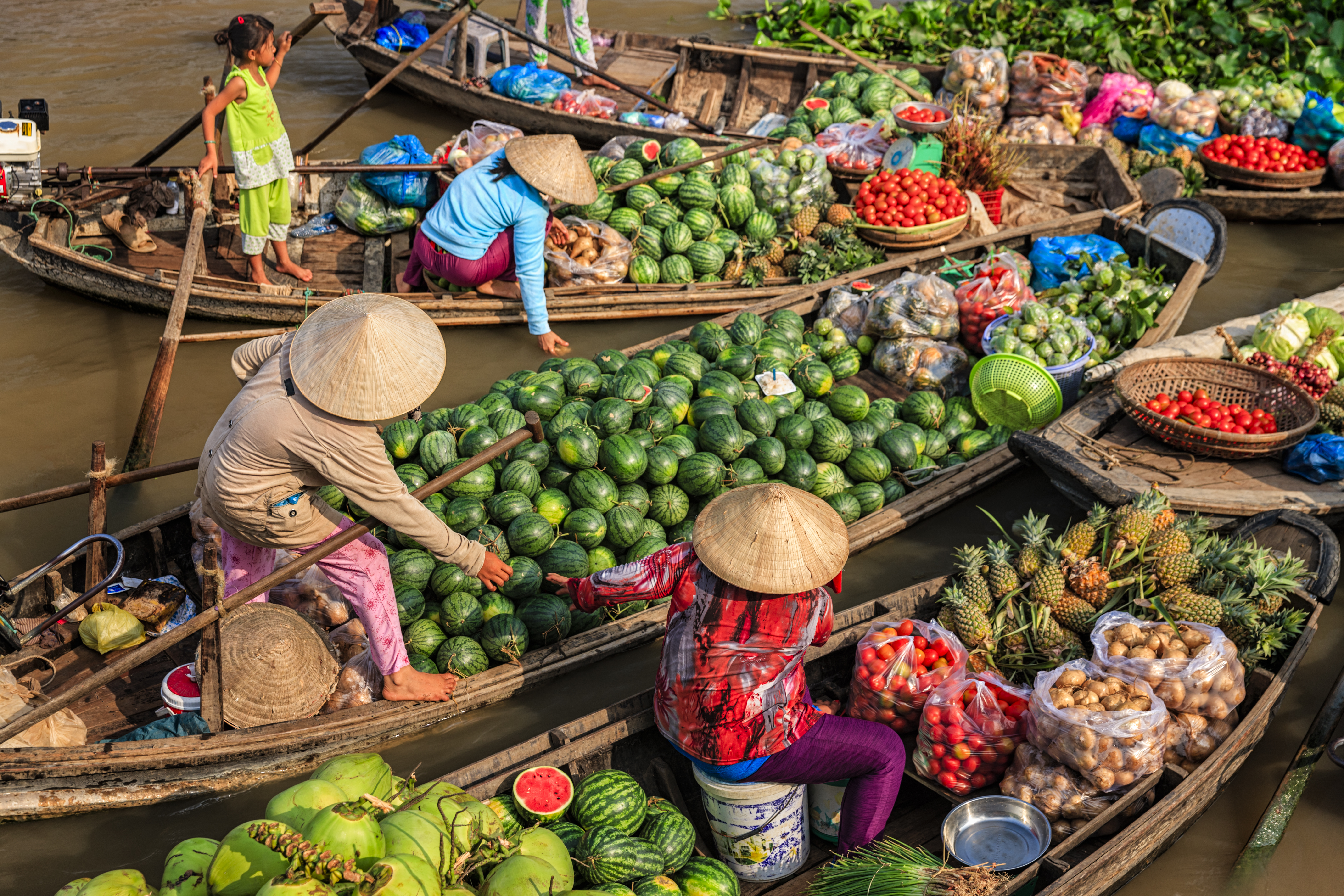 Fruit sellers on the Mekong River Delta, selling fruit from boats, watermelons, pineapples, tomatoes