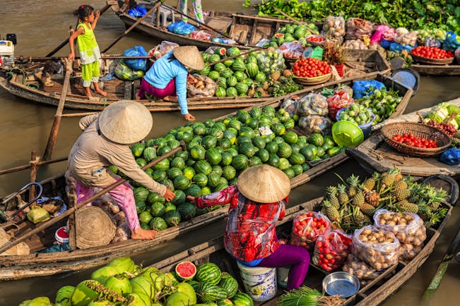 Fruit sellers on the Mekong River Delta, selling fruit from boats, watermelons, pineapples, tomatoes