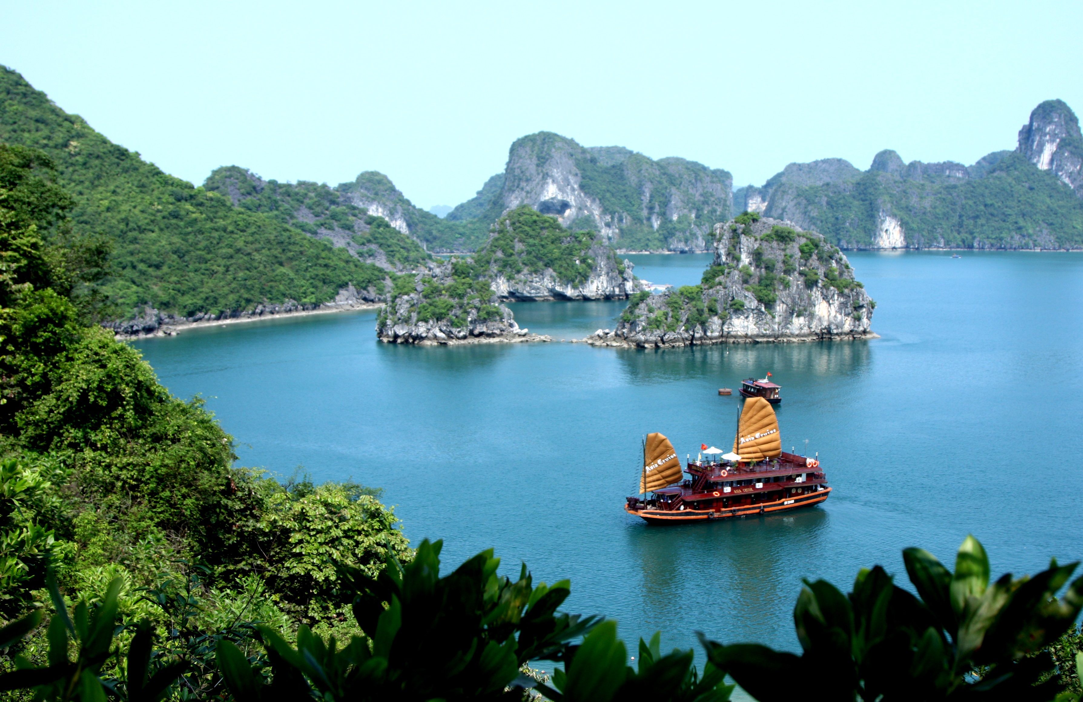 Ha Long Bay, junk boat on the water, surrounded by rock formations, sea 