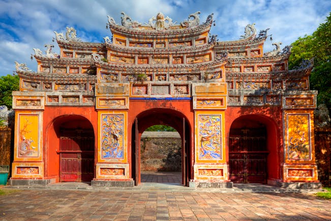 Gate at the imperial city citadel in Hue, colourful structure with carvings and paintings