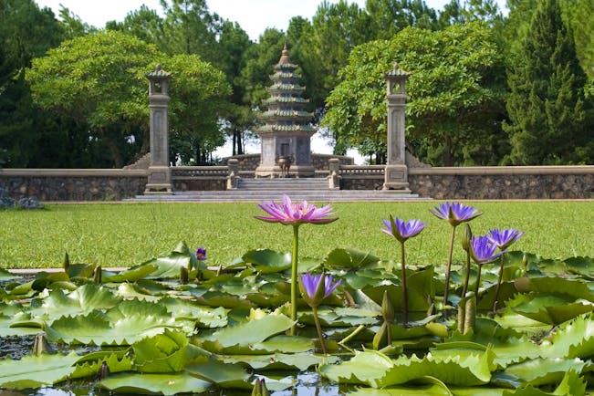 Thien Mu Pagosa, pink and purple water lilies, verdant lawn, intricate pagoda
