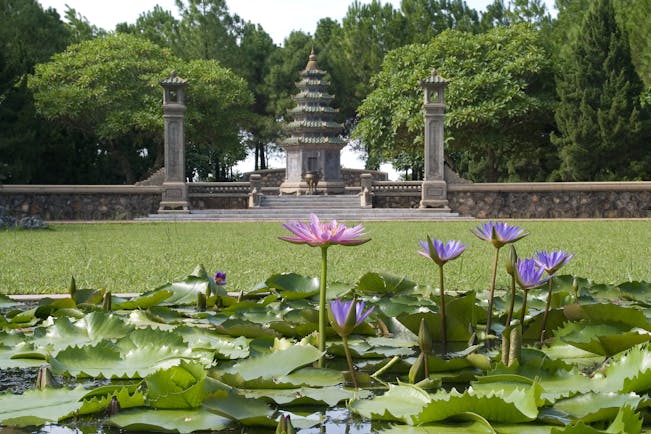 Thien Mu Pagosa, pink and purple water lilies, verdant lawn, intricate pagoda