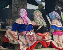 Women sitting with backs to the camera, dining, traditional dress, headscarves