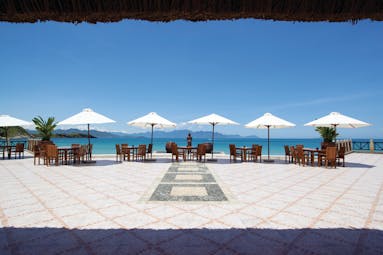 Vinpearl Luxury Nha Trang Vietnam beach view dining terrace tables chairs umbrellas