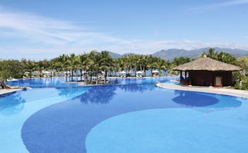 Vinpearl Luxury Nha Trang Vietnam pool palm trees mountains in background