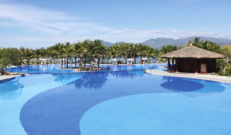 Vinpearl Luxury Nha Trang Vietnam pool palm trees mountains in background