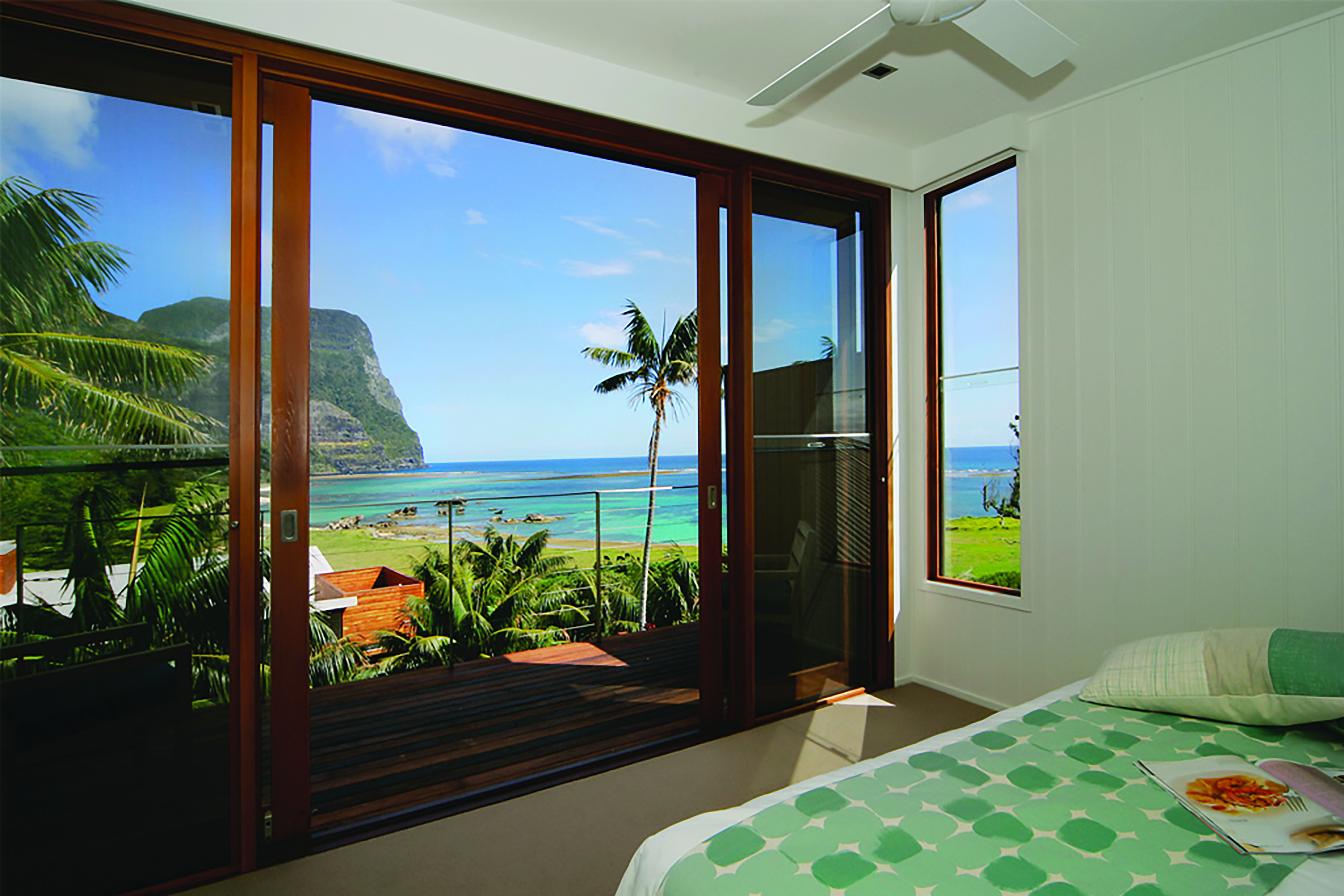 Capella Lodge lagoon loft guestroom, double bed, balcony overlooking bay and coastline