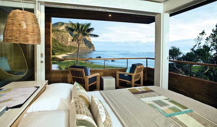 Capella Lodge Lidgbird Pavilion guestroom, double bed, chairs, room overlooking bay and coastlibe