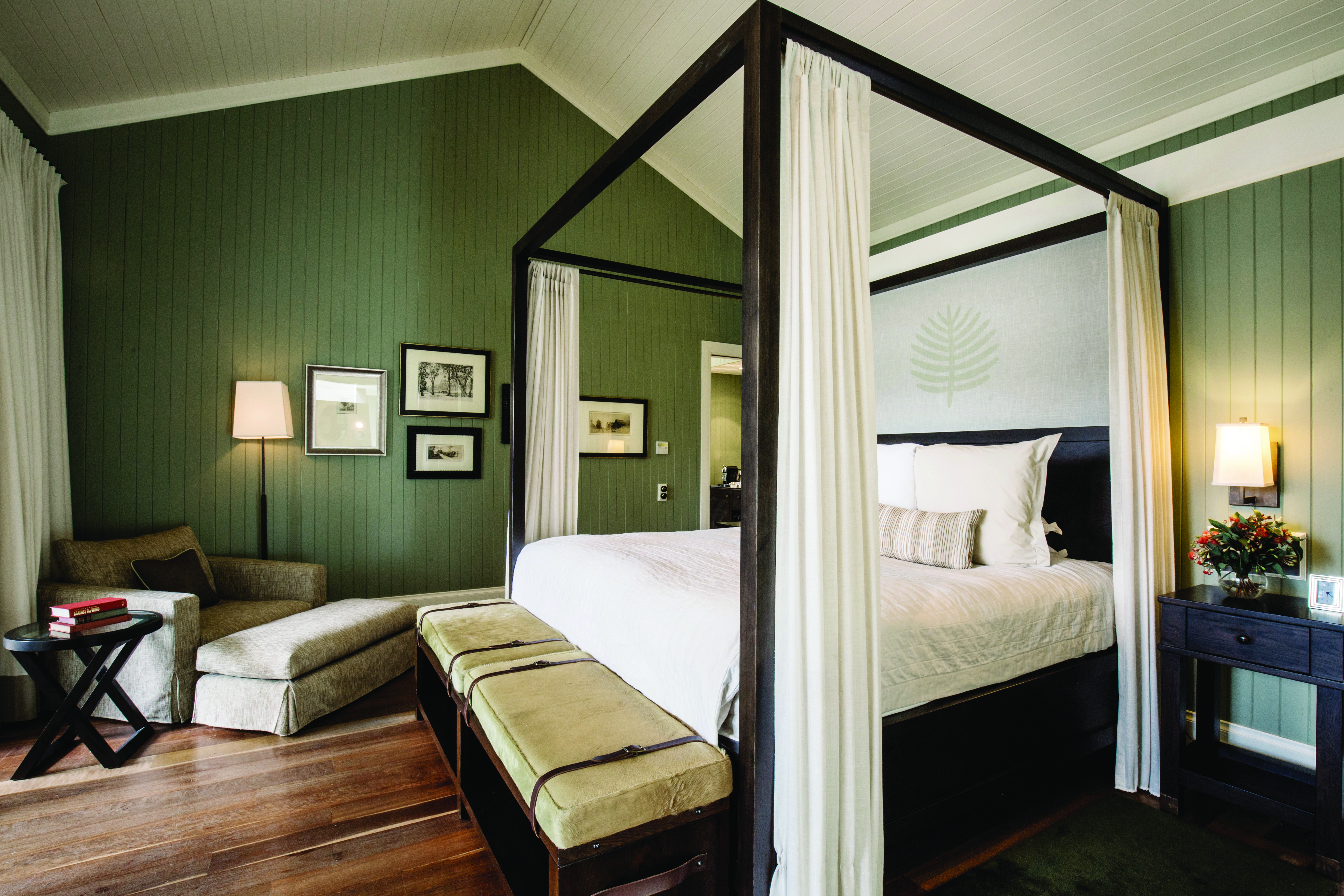 Main bedroom with four poster bed, drapes and paintings on the wall