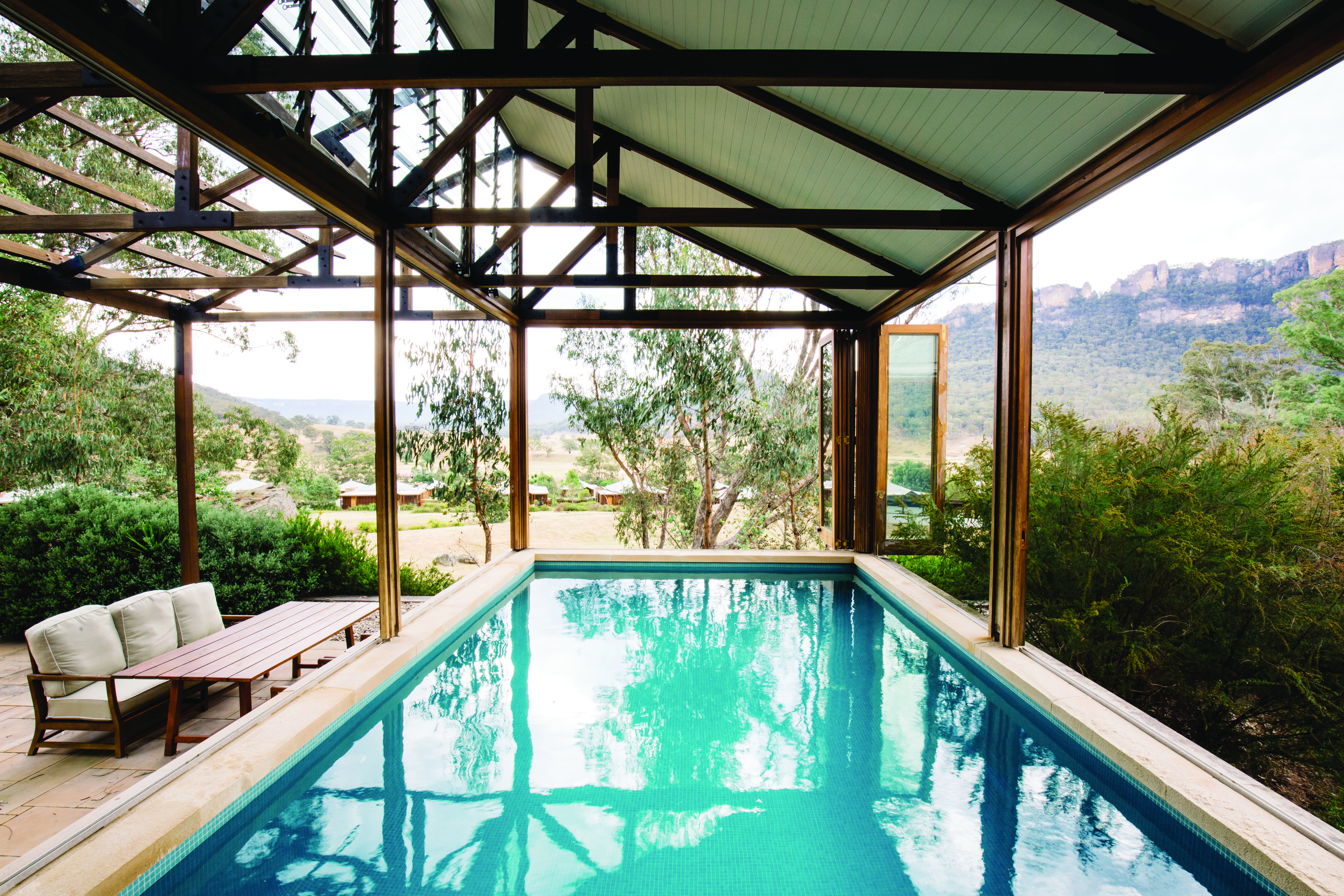 Terrace swimming pool with a veranda over it and sun loungers around