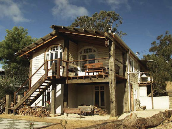 Old Leura Dairy New South Wales exterior wooden building with log piles and stairs up to rooms