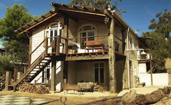 Old Leura Dairy New South Wales exterior wooden building with log piles and stairs up to rooms