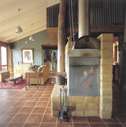 Old Leura Dairy New South Wales straw lounge area with sofa and log fire
