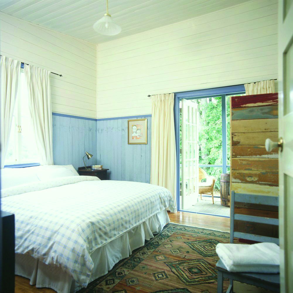Old Leura Dairy New South Wales workers bedroom with blue and white wooden walls and patio door to balcony
