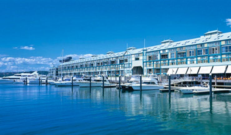 Ovolo Woolloomooloo Sydney exterior waterfront building with awnings near marina with boats