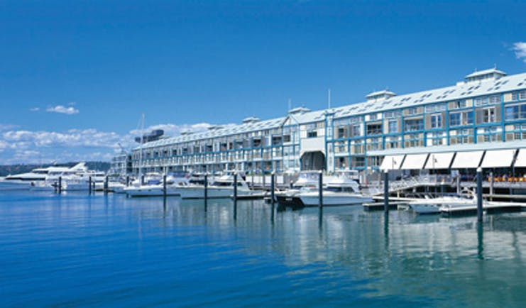 Ovolo Woolloomooloo Sydney exterior waterfront building with awnings near marina with boats