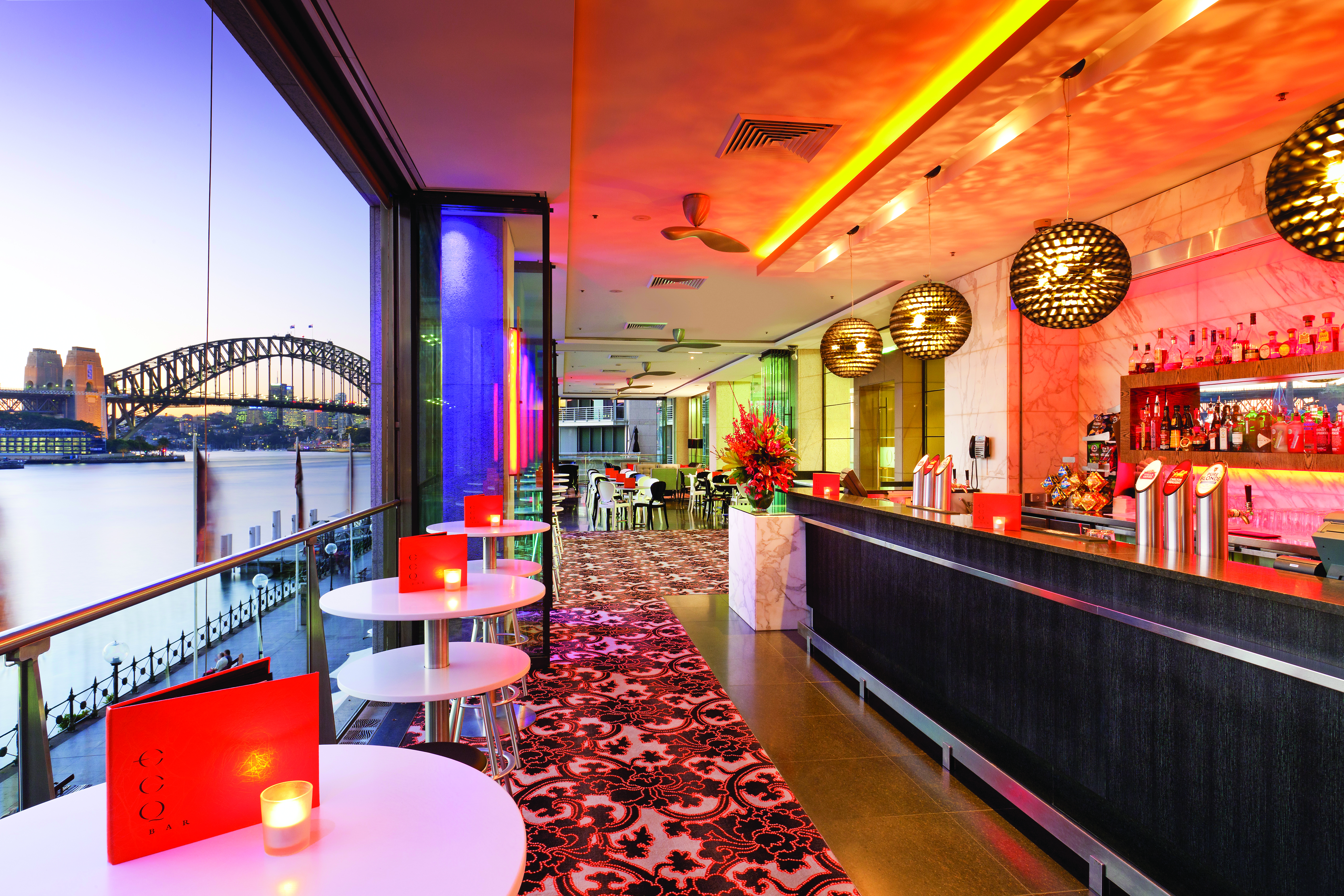 Pullman Grand Quay Sydney bar area with view of harbour bridge at night