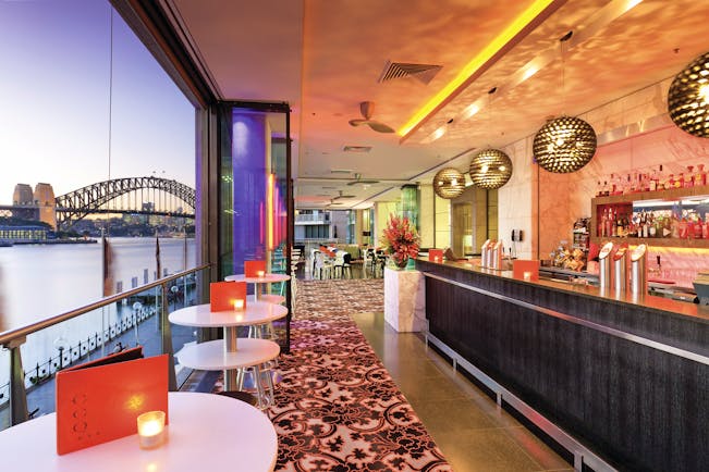 Pullman Grand Quay Sydney bar area with view of harbour bridge at night