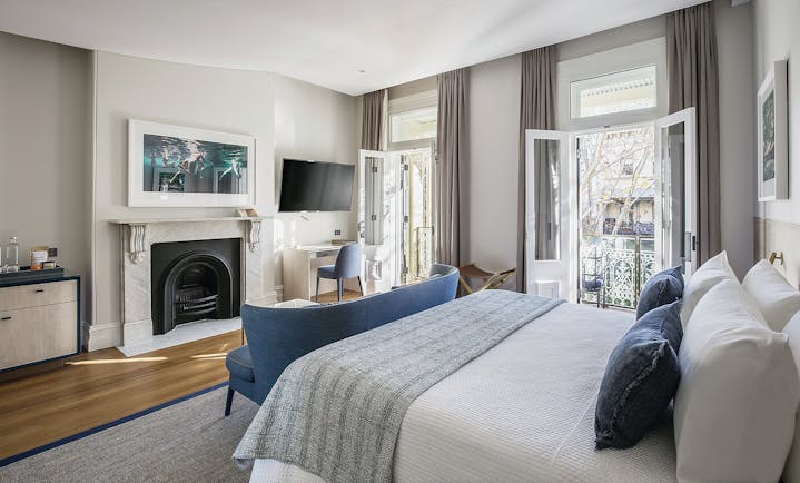 Spicers Potts Point terrace suite with double bed, open fireplace, and balcony