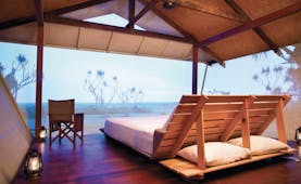Bamurru Plains lodge interior, double futon bed, netted walls overlooking outback