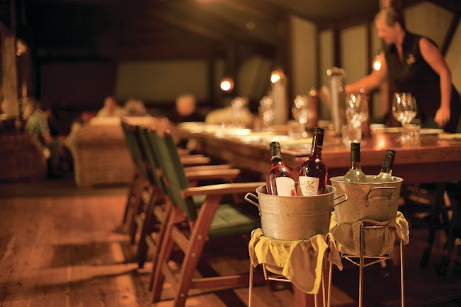 Bamurru Plains restaurant, tables set for eating, waitress, wine in bucket in main focus