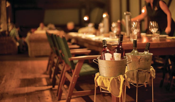 Bamurru Plains restaurant, tables set for eating, waitress, wine in bucket in main focus