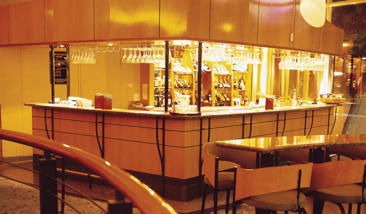 Sails in the Desert bar area with hanging glasses and bar stools