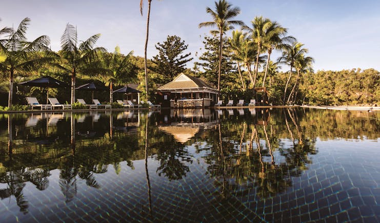 Orpheus Island pool, sun loungers, poolside bar, palm trees