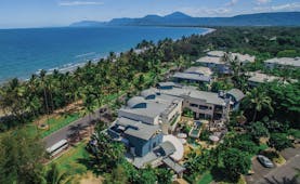 Port Douglas Peninsula Queensland aerial beach view of hotel complex with outdoor pool and palm trees near coast