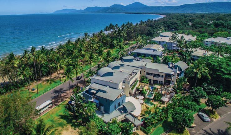 Port Douglas Peninsula Queensland aerial beach view of hotel complex with outdoor pool and palm trees near coast