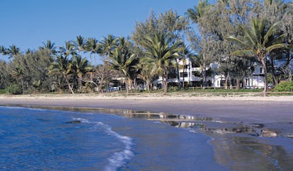 Port Douglas Peninsula Queensland beach front white building and palm trees near beach and sea